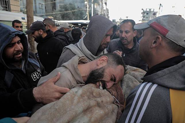 A man mourns over a victim killed in an Israeli airstrike at the Al-Awda Hospital in the al-Nuseirat refugee camp, central Gaza Strip, on Dec. 13, 2024. (Photo by Rizek Abdeljawad/Xinhua)