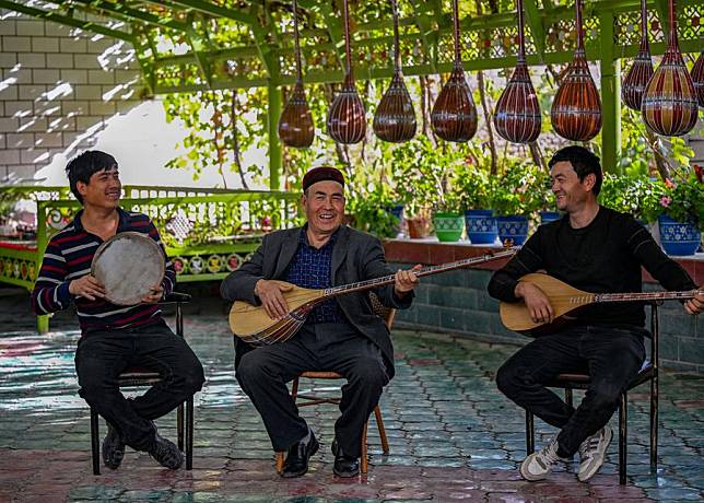 Nurdun Esmayil &copy; plays music with his son, Ehmet Nurdun (L), and his apprentice in his courtyard in Xinhe County, northwest China's Xinjiang Uygur Autonomous Region, Oct. 15, 2024. (Xinhua/Chen Shuo)