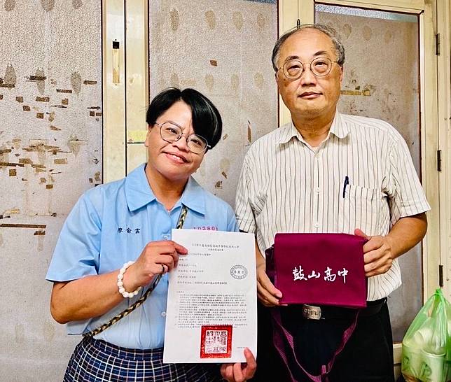 鼓山高中校長廖俞雲（左）穿著制服，與七賢國中校長邱元甫送上錄取通知單告慰家屬。（高雄市教育局提供）