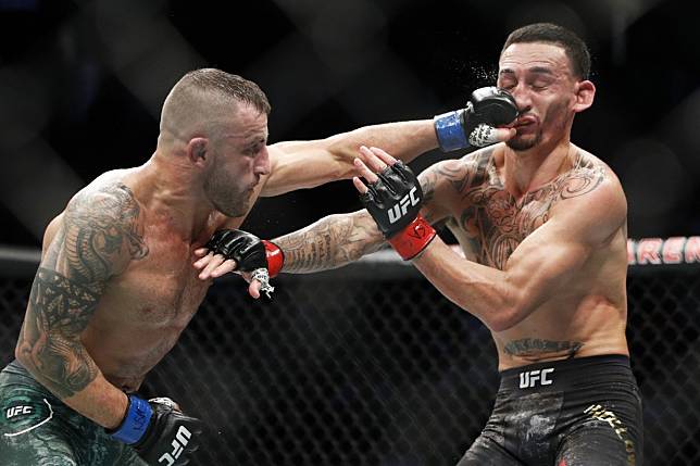 Alexander Volkanovski hits Max Holloway in their featherweight championship bout at UFC 245. Photo: AP