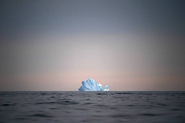 An iceberg floats away as the sun sets near Kulusuk, Greenland, on August 15. As warmer temperatures cause the ice to retreat, the Arctic region is taking on new geopolitical and economic importance, with the US, Russia, China and others all wishing to stake a claim. Photo: AP