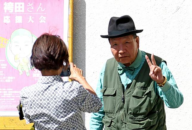 獲釋後的袴田巖最喜歡散步，2023年3月他在靜岡街頭比YA拍照。圖片來源：讀賣新聞 / AP / 達志影像