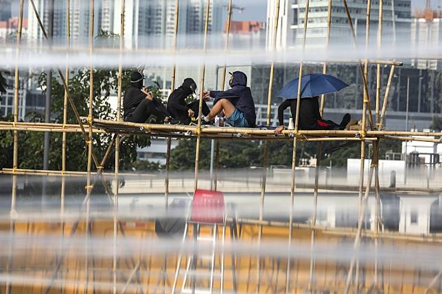 Anti-government protesters set up roadblocks with water-filled barricades and bamboo rods outside the Baptist University campus in Kowloon Tong. Photo: Xiaomei Chen
