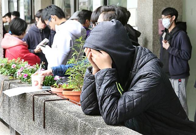 2018年1月27日　台北市　大學學測第2天，考生在考場教室門口摀著臉，沈靜下來等待進場。（姚志平攝）