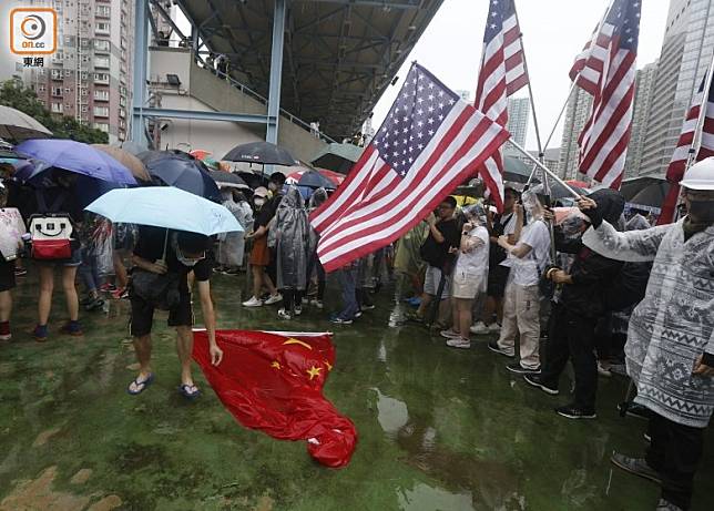 示威者手持美國國旗，五星旗則被放於地下。(何天成攝)