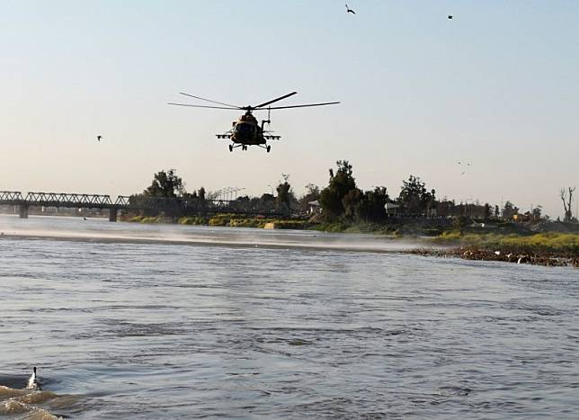 一架伊拉克直升機在失事水面上空尋找是否有生還者。(路透)