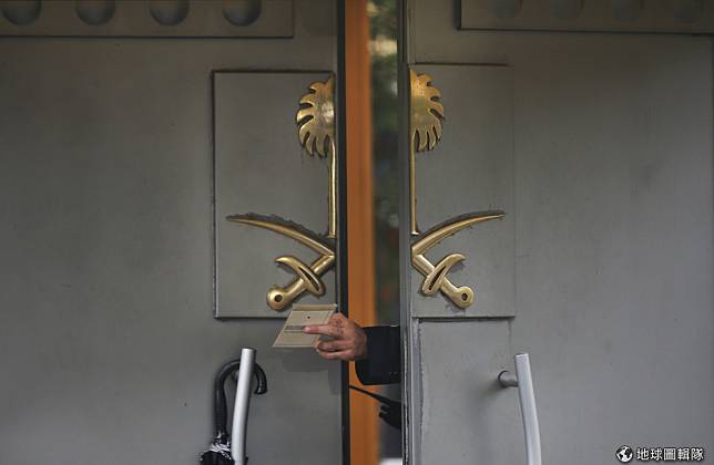 一名沙國駐伊斯坦堡領事館的維安人員將大門大開一條縫，遞交文件給駐守在門外的同事。 美聯社/達志影像