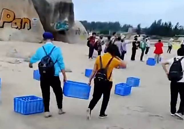 中國民眾提著礦泉水到海邊。(圖/翻攝自微博)