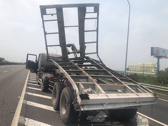 半聯結貨櫃車所載運貨櫃不明原因彈，致使貨櫃卡在跨越橋及中線車道中間。（民眾提供）