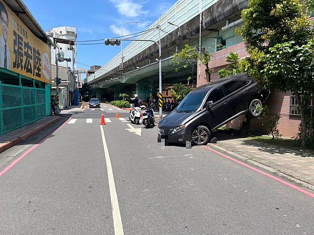 柯姓老翁自撞後，車屁股直接爬牆掛在空中。翻攝畫面