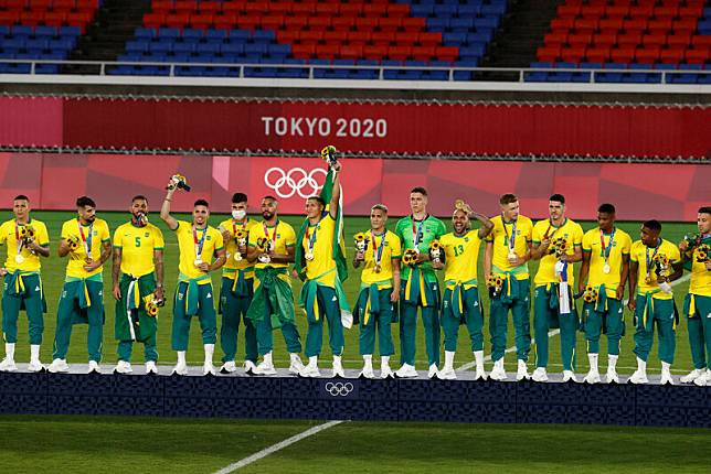 巴西男足成功衛冕奪金，在頒獎典禮時卻拒絕穿上贊助商「中國匹克」的運動服，而是將其綁在腰上。   圖：達志影像/美聯社