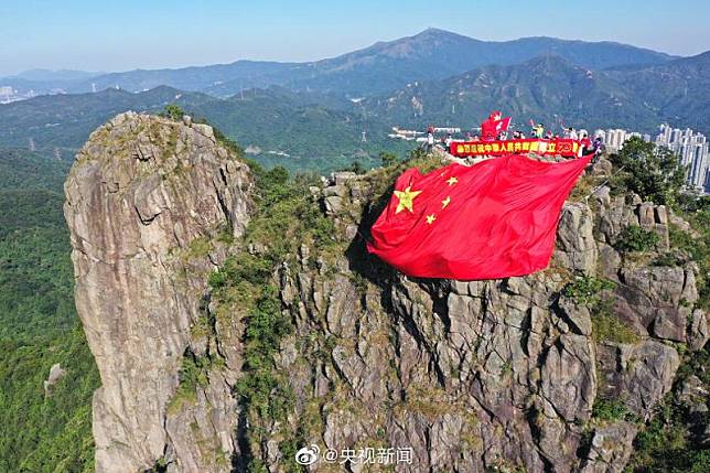 有人今早登上獅子山掛大型國旗（央視新聞微博圖片）