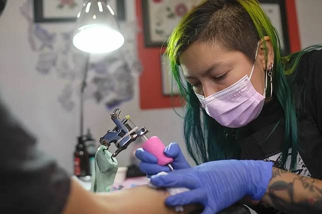 刺青師傅正在替客戶進行圖案製作。（AP）
