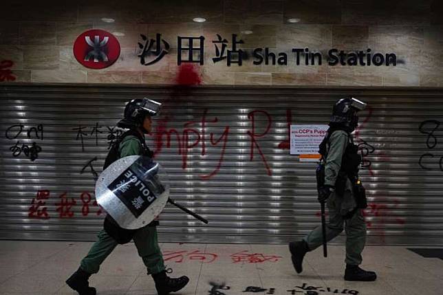 兩名香港警察在沙田站驅趕抗爭者。（美聯社）