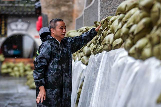 Staff members reinforce flood defence with sandbags at the Luo Dongshu ancestral hall in Chengkan Village of Huizhou District, Huangshan City, east China's Anhui Province, June 27, 2024. (Photo by Shi Yalei/Xinhua)