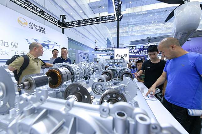 Visitors learn about a 800V dual-motor drive system for the new energy vehicle (NEV) at an exhibition on the sidelines of the 2024 World Power Battery Conference in Yibin, southwest China's Sichuan Province, Sept. 1, 2024. (Xinhua/Tang Wenhao)