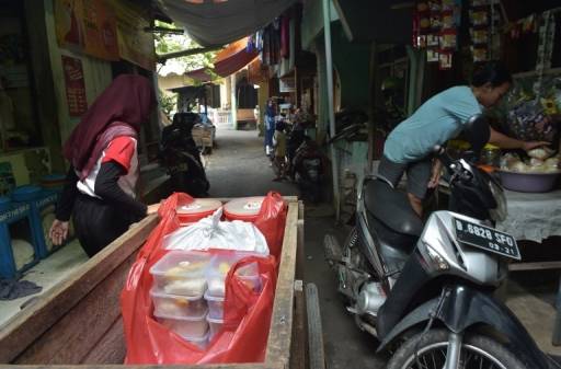 AFP / ADEK BERRY อาสาสมัครโครงการ Blessing to Share แบ่งปันอาหารที่เหลือจากการมงคลสมรสไปให้ผู้ยากไร้ในสลัมของประเทศอินโดนีเซีย