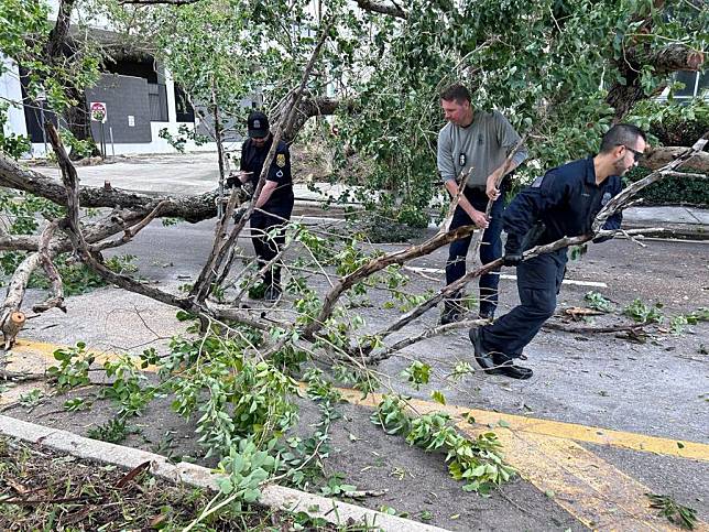 Police officers and National Guard members clear a downed tree after Hurricane Milton strikes on Davis Island, Tampa City, Florida, the United States, on Oct. 10, 2024. (Photo credit: City of Tampa)