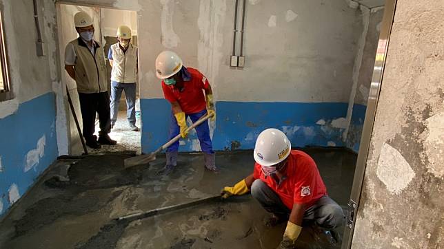 泥水志工犧牲假期為弱勢家庭房屋修繕，勞工局長王鑫基（左）到場向志工致意。（勞工局提供）