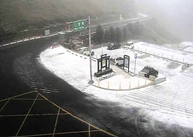 合歡山遊客服務中心停車場，因下冰霰地面雪白。(記者陳鳳麗翻攝自合歡山即時影像)