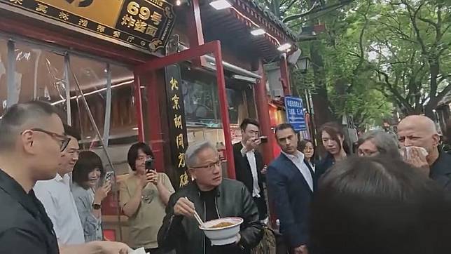 黃仁勳之前站在店外捧著大碗吃炸醬麵，邊和周圍民眾聊天。翻攝自「今事」微博