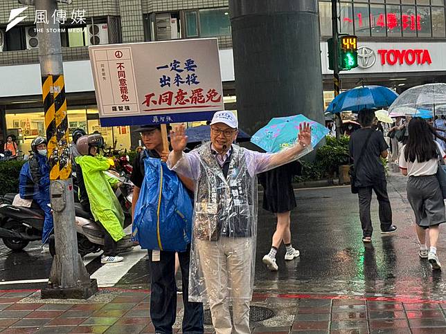 國民黨立委羅智強冒雨在捷運站出口宣傳反罷免。（風傳媒攝）