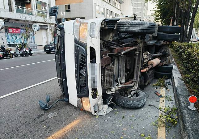 台中市北區中清路昨日發生轎車疑似違規超車，與另輛貨車擦撞，導致貨車失控撞上中央分隔島翻覆於路車。（記者陳金龍翻攝）