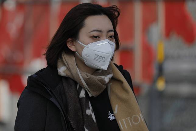 A passenger wears a protective mask at a Beijing railway station on Friday. Photo: EPA-EFE