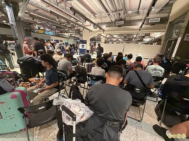 巴威颱風攪局打亂基隆港船班，新台馬輪旅客被安排在2樓電梯口格外擁擠。(記者俞肇福攝)