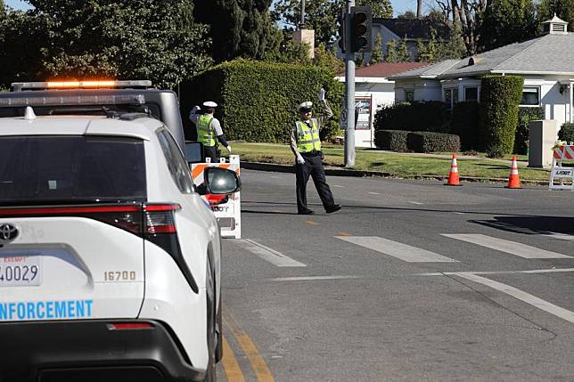 Officers work on the road as the routes leading to areas ravaged by the Palisades fire remain closed in Los Angeles County, California, the United States, on Jan. 13, 2025. (Photo by Qiu Chen/Xinhua)