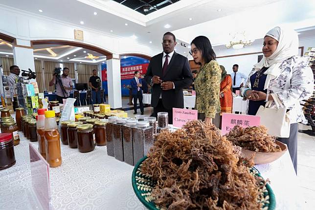 Chinese Ambassador to Tanzania Chen Mingjian &copy; and Tanzania's Zanzibar Minister for Trade and Industrial Development Omar Said Shaaban (L) listen to an introduction of a Tanzanian enterprise's products at a send-off ceremony for Tanzanian exhibitors attending this year's China International Import Expo (CIIE), held at the Chinese Embassy in Dar es Salaam, Tanzania, Oct. 14, 2024. (Photo by Emmanuel Herman/Xinhua)