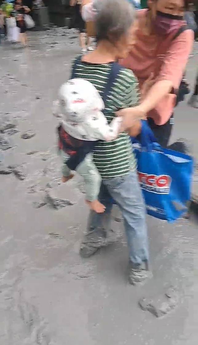 一名老年人揹著嬰兒、手提著大袋子差點跌到。（圖／中天新聞）