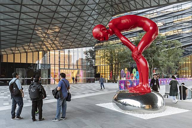 Employees stand next to a sculpture at the Ant Financial headquarters in Hangzhou, China. Photo: Bloomberg