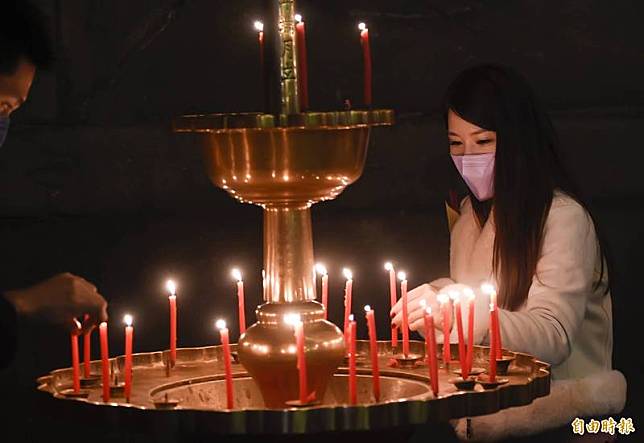 民眾於除夕夜到台北市大龍峒保安宮上香點燈祈福。(記者陳志曲攝)