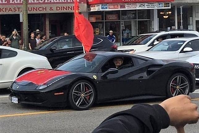 A Ferrari draped in Chinese flags drives past Hong Kong protesters and pro-China counter-protesters in Vancouver, Canada. Photo: Kevin Huang Yi Shuen