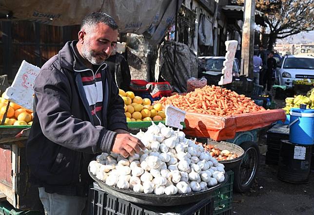 A vendor displays goods for sale along a street in Damascus, Syria, Dec. 16, 2024. (Photo by Ammar Safarjalani/Xinhua)