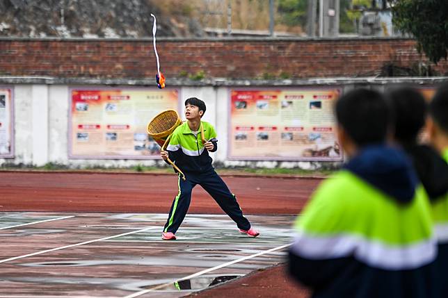 A student catches a embroidered ball with a basket in Yulin Ethnic Middle School in Yulin, south China's Guangxi Zhuang Autonomous Region, Feb. 19, 2025. (Xinhua/Cao Yiming)