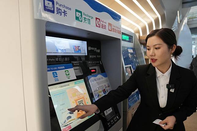 A staff member introduces recharging process of the Beijing Pass, a multi-purpose card designed to enhance convenience for international visitors by simplifying payments for transportation, tourist sites and shopping centers, at a service counter in Beijing Capital International Airport in Beijing, capital of China, Jan. 8, 2025. (Xinhua/Ju Huanzong)