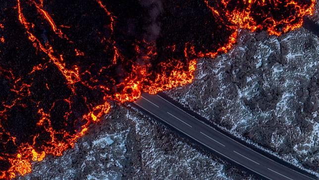 冰島雷克雅內斯半島的火山上周噴發，炙熱的熔岩慢慢吞噬柏油路，往度假勝地「藍湖溫泉」前進。美聯社