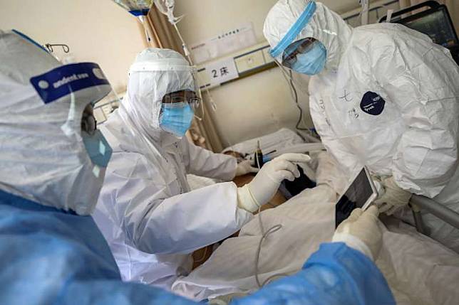 中國河北省武漢市，醫護人員正在檢查一位感染新冠病毒肺炎的患者。新冠肺炎、武漢肺炎。（AP）