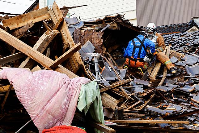 日本1日發生大地震，救難人員深入災區救援。（路透社）