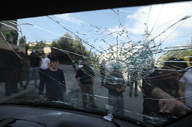 People look at a vehicle damaged in an Israeli raid in the West Bank city of Nablus, on April 15, 2024. (Photo by Ayman Nobani/Xinhua)