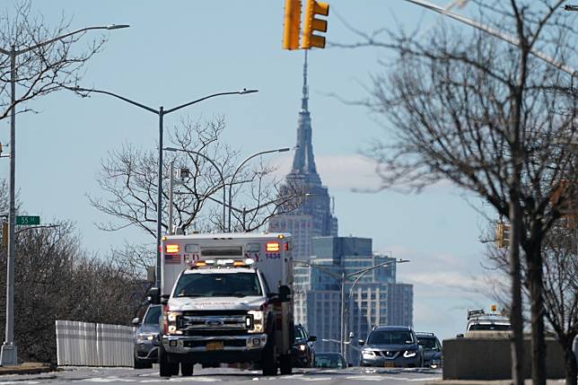 The Empire State Building rises over an ambulance in New York City on March 24, 2020. Photo: EPA-EFE
