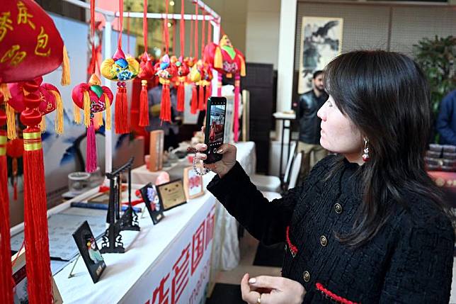 A woman visits a decorations stall during an event welcoming the Chinese New Year in Islamabad, capital of Pakistan, on Jan. 11, 2025. (Xinhua/Ahmad Kamal)