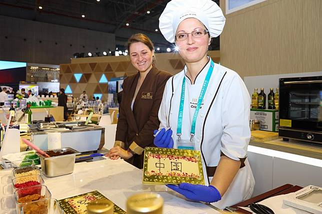 Exhibitors of Swiss chocolate maker Heidi shows a bar of chocolate with the pattern reading &ldquo;China&rdquo; on its surface at the Food &amp; Agricultural Products area of the first China International Import Expo (CIIE) in Shanghai, east China, on Nov. 7, 2018. (Xinhua/Liu Dawei)