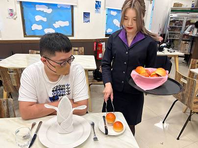 南強工商觀光事業科學生張芯瑀(右)順利考上國立高雄餐旅大學航空暨運輸服務管理系，延續對休閒產業的熱情。圖為進行餐飲服務技術及航空業務實作課程。 圖：新北市教育局提供