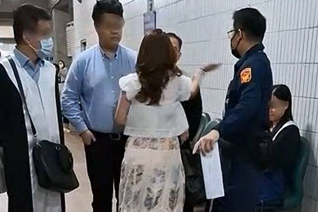 林女（白衣背對者）因攻擊及恐嚇律師案再度開庭，她在法庭內情緒再度失控，不但高喊「我打全世界律師巴掌」，甚至與法警發生拉扯，遭當場壓制上銬。資料照片